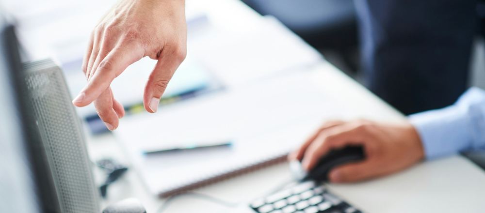 IT specialist helping a colleague at a computer