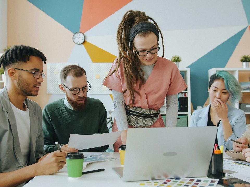 Colleagues working together around a laptop